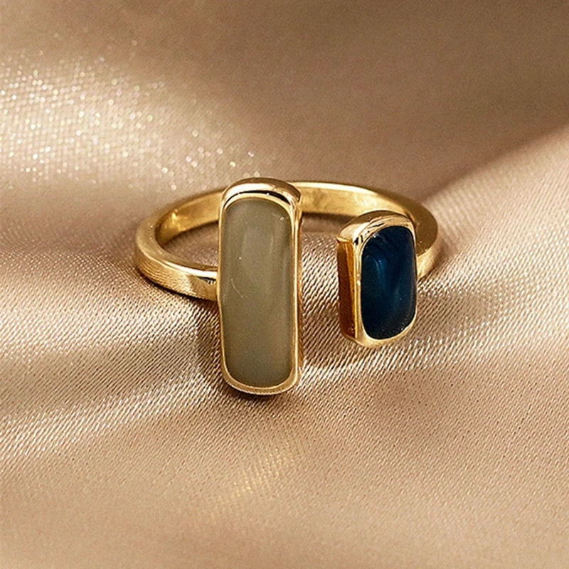 Goudkleurige ring met twee rechthoekige stenen in contrasterende tinten. Deze elegante ring van Brenzo straalt tijdloze klasse uit en is het perfecte accessoire om elke outfit te verrijken. Ideaal voor dagelijks gebruik of speciale gelegenheden.